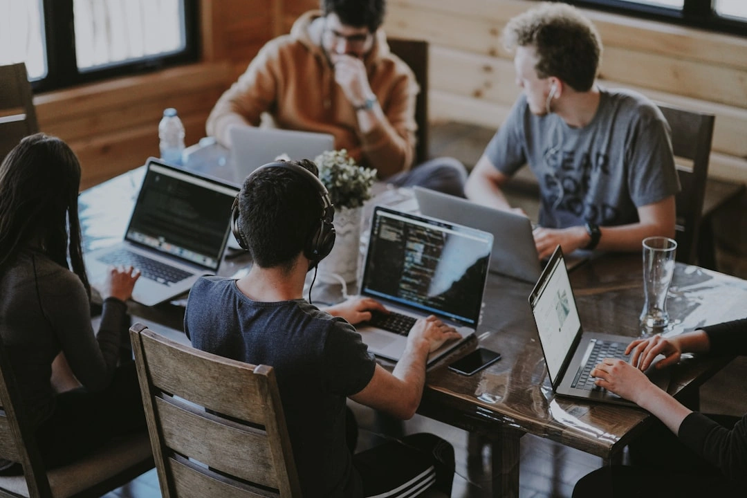 Un team di sviluppatori collabora su laptop in un ufficio moderno